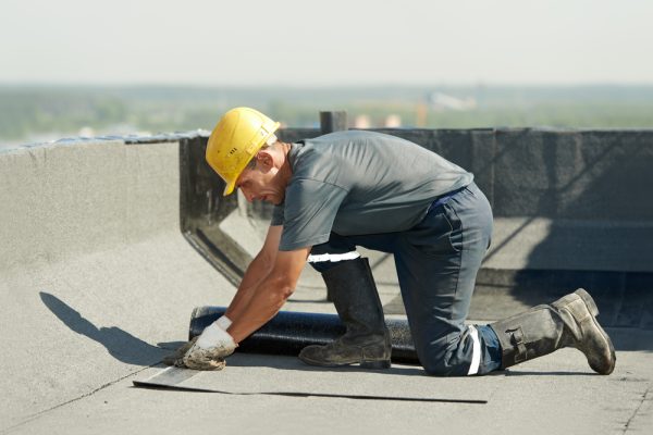 Roofer,Preparing,Part,Of,Bitumen,Roofing,Felt,Roll,For,Melting