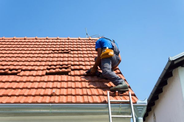 tile-roof-repair-roof-tech-standing-on-a-roof-repairing-tile-shingles