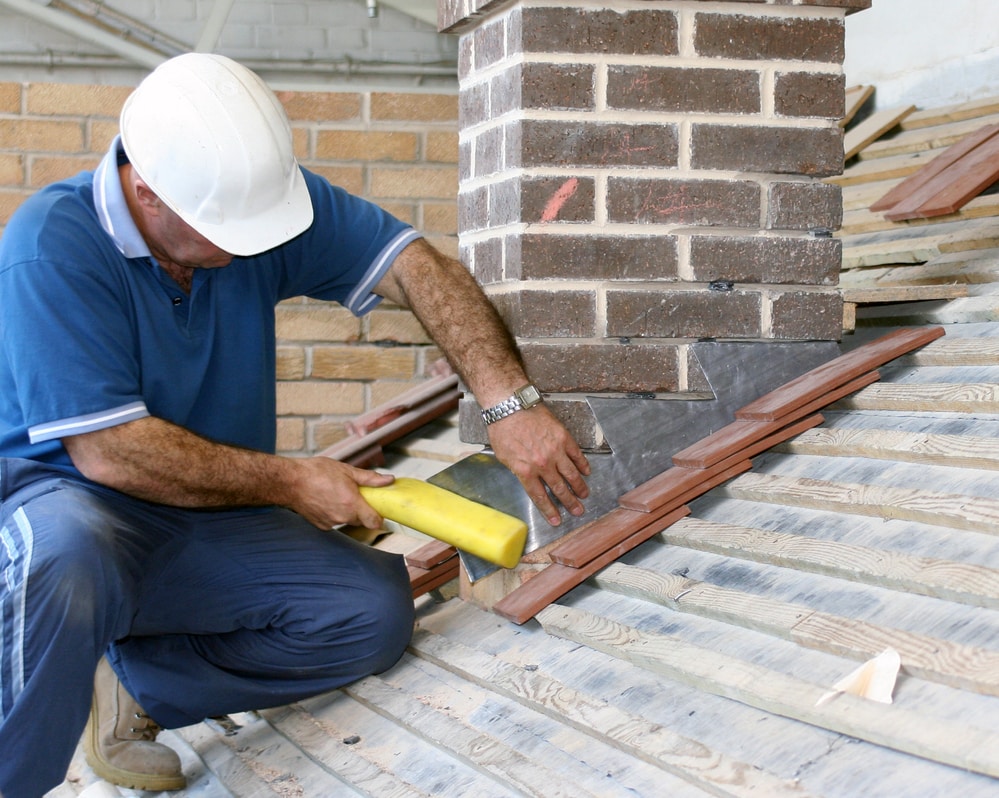Roofer-repairing-flashing-around-chimney