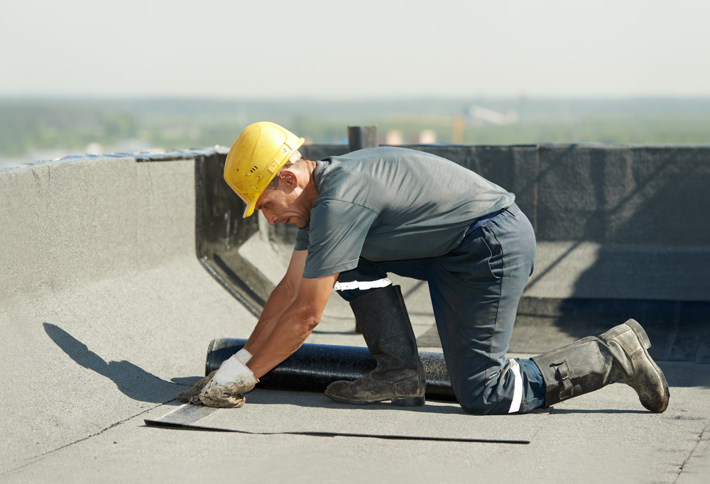 Roofer,Preparing,Part,Of,Bitumen,Roofing,Felt,Roll,For,Melting